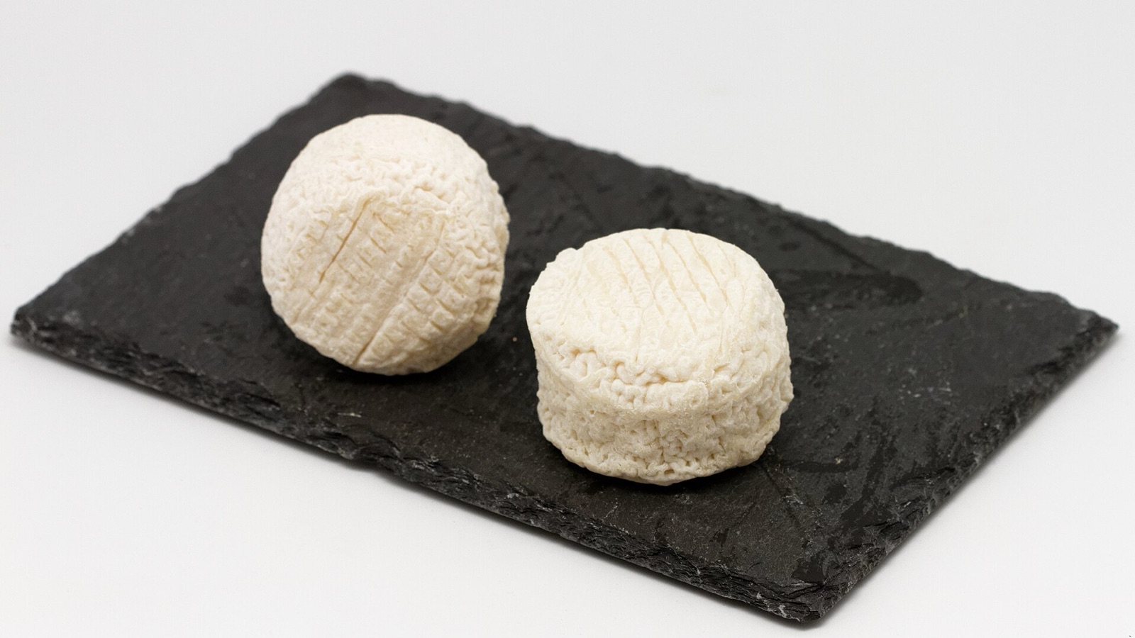 Crottin de Chavignol goat cheeses on a simple board