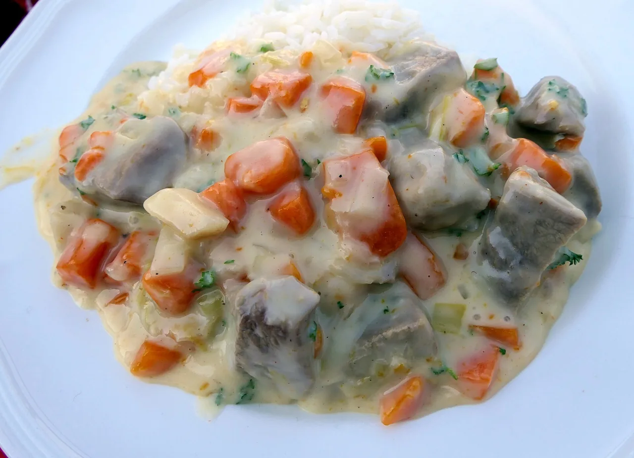 Blanquette de veau with carrots in a cream sauce over rice