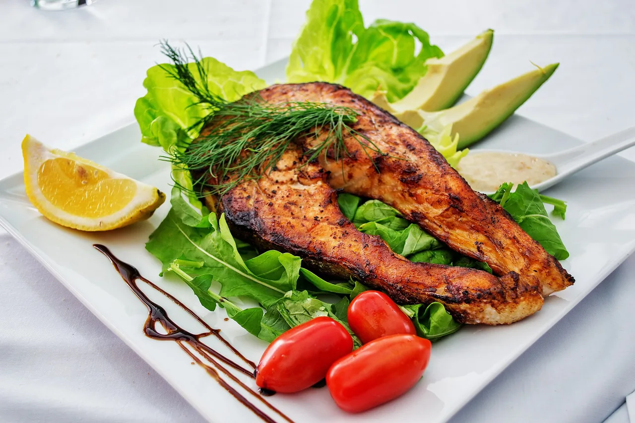 Grilled salmon with dill, salad leaves, avocado and lemon
